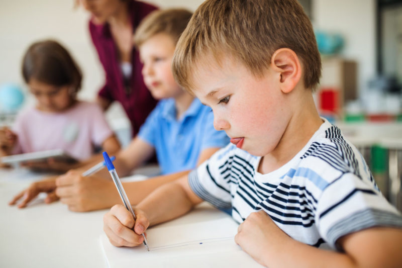 Enfant qui se concentre pour écrire