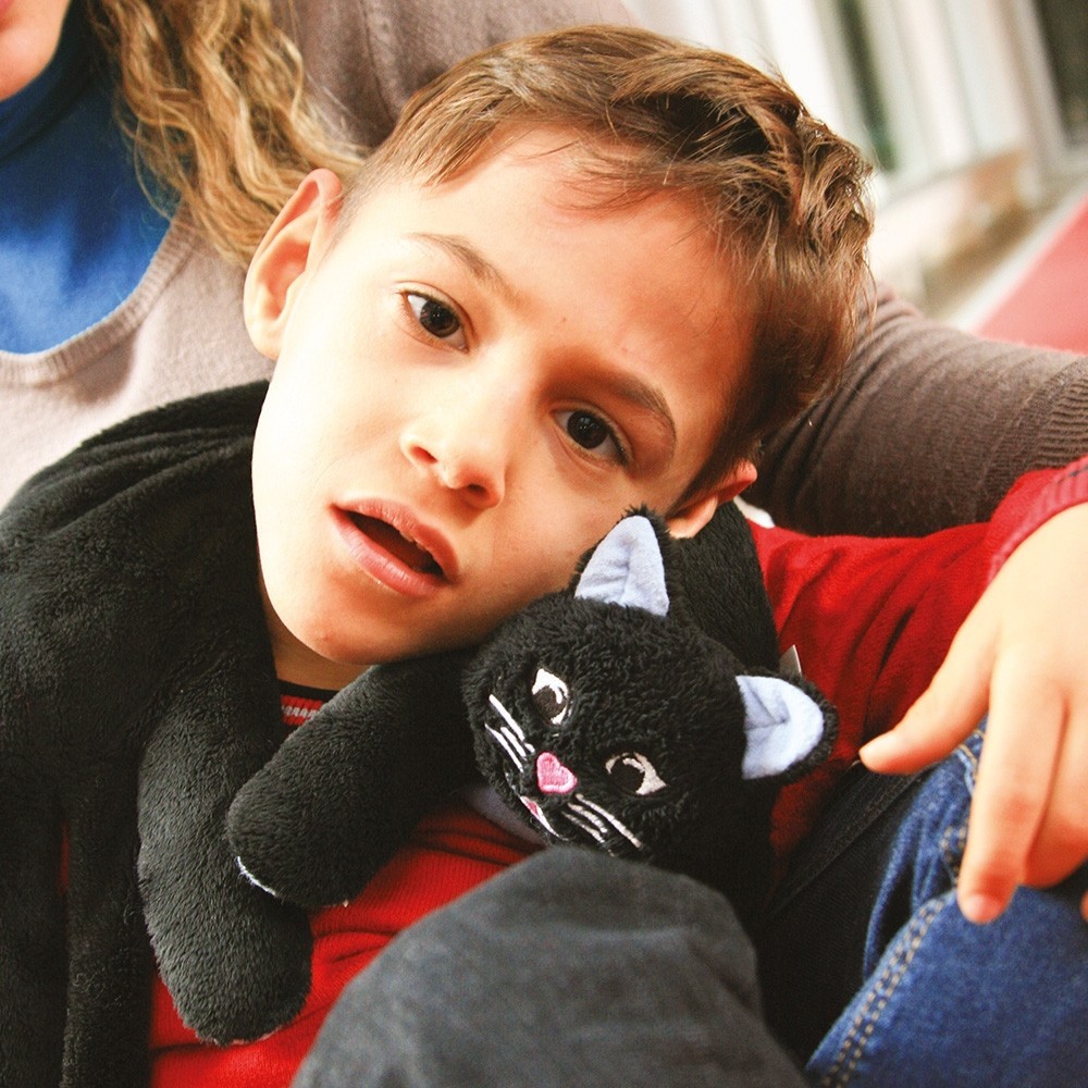 Un enfant avec le chat lesté sur les épaules.