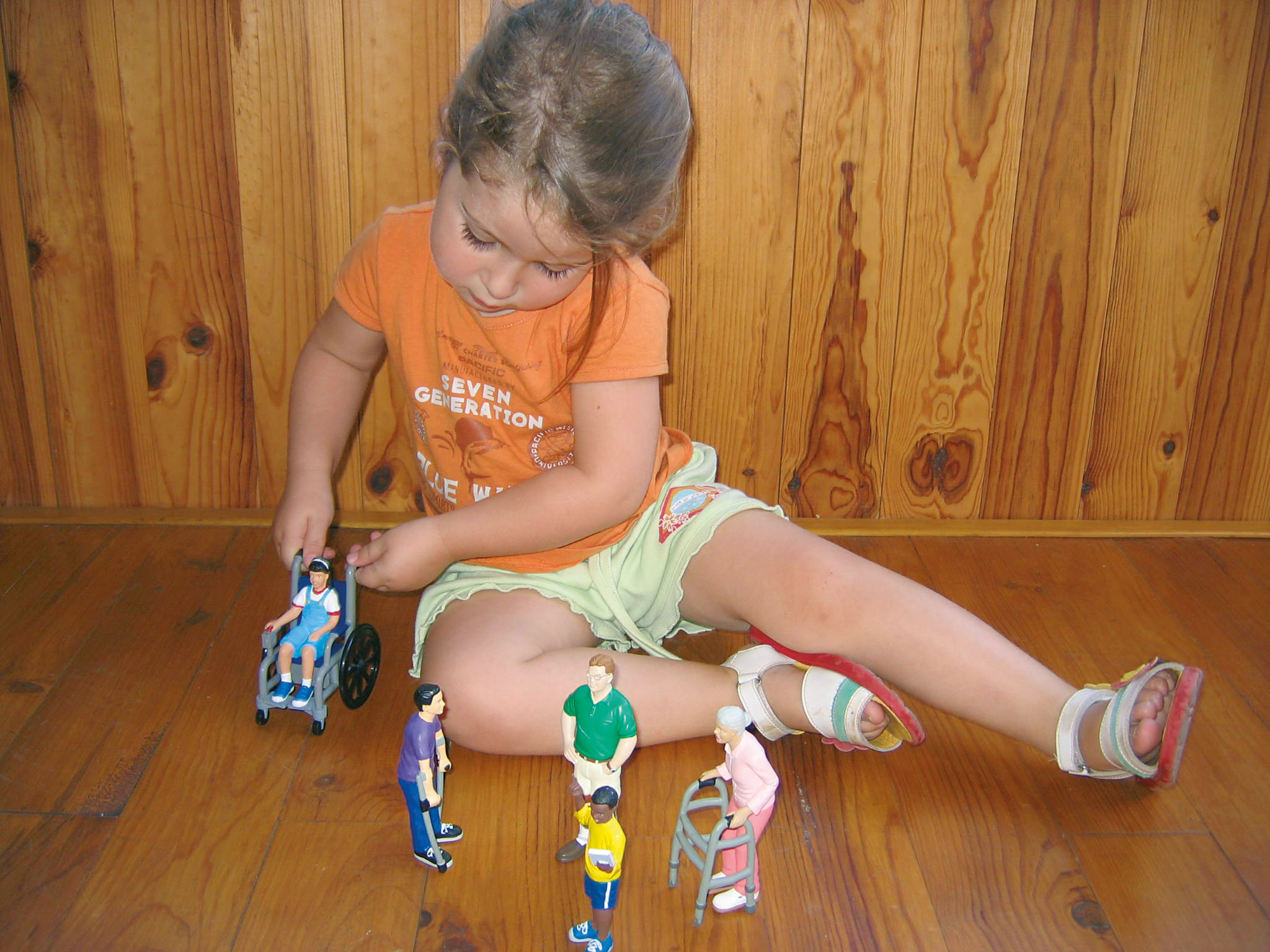 Une petite fille qui joue avec des figurines de personnes en situation de handicap
