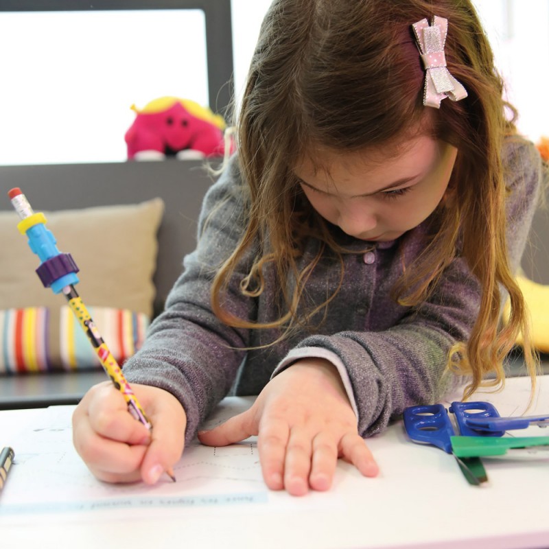 Un enfant écrit avec un crayon fidget sur une feuille