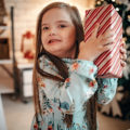 Une enfant tient un cadeau de Noël