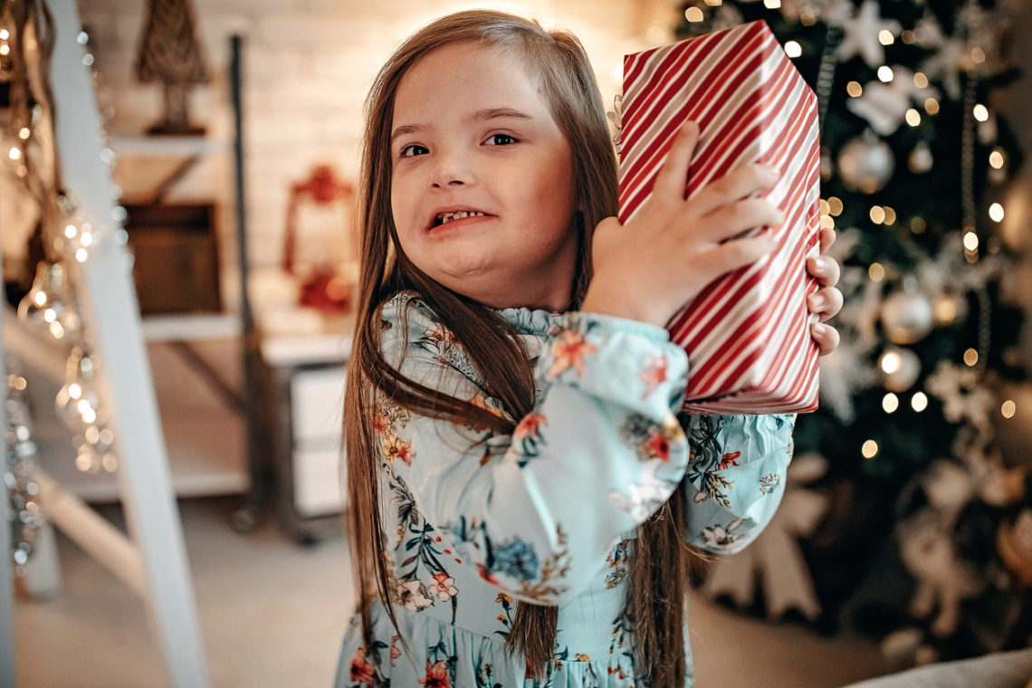 Une enfant tient un cadeau de Noël