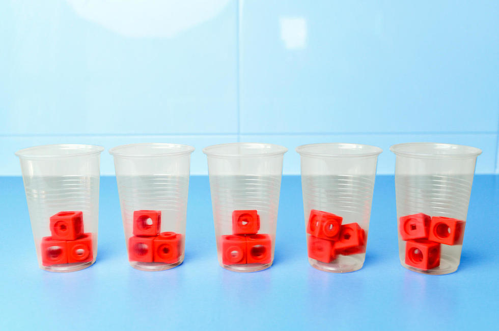 Des gobelets en plastique contiennent chacun 3 cubes Mathlink rouges