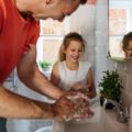 Une fille et son père se lavent les mains