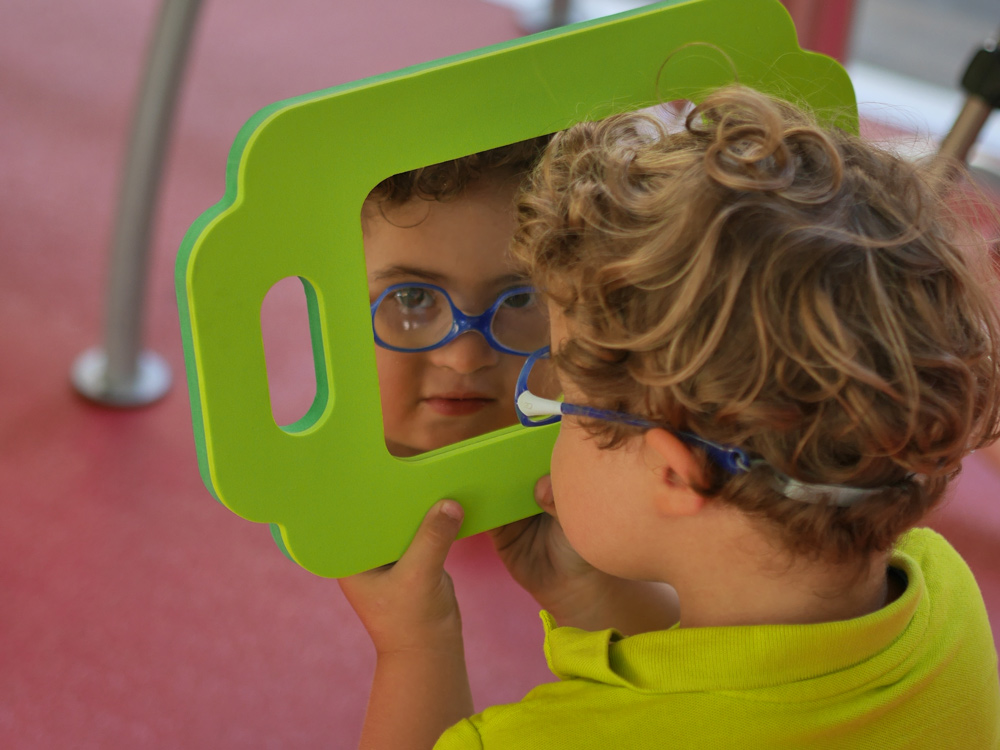 Un enfant se regarde dans un miroir