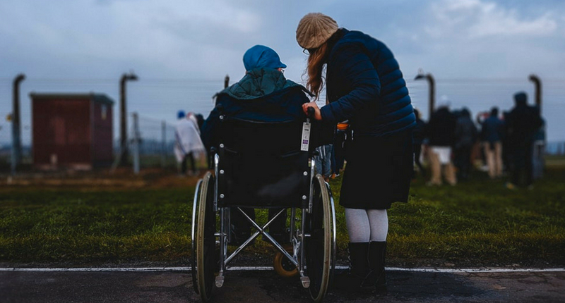 Une personne en fauteuil accompagnée