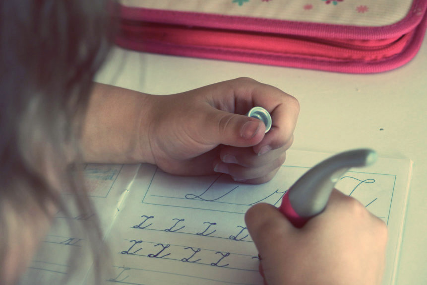 Une enfant qui écrit avec un stylo ergonomique.