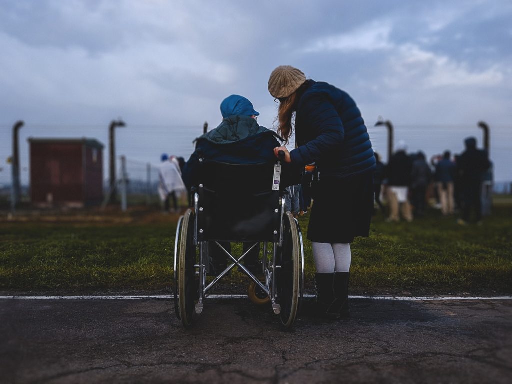 Aidant et personne en fauteuil regardent dans la même direction 