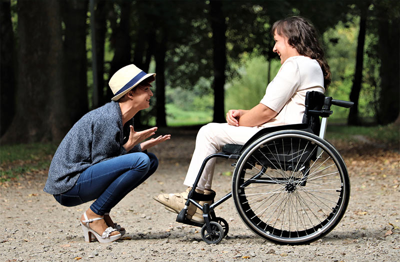 Aidante avec personne en fauteuil roulant en extérieur