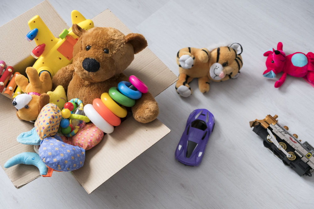 Des jouets et peluches dans une boîte en carton