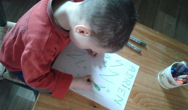 Un enfant trace des lettres