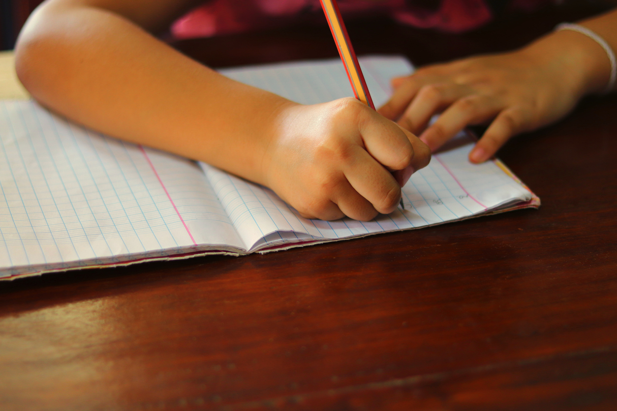 enfant qui écrit dans un cahier