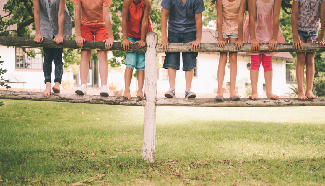 Des enfants sur une barrière en bois