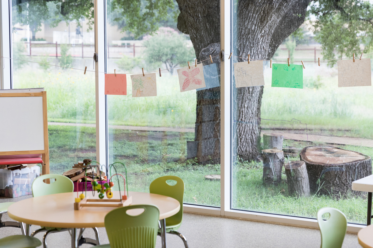 Salle de classe aux grandes fenêtres qui donnent sur un extérieur verdoyant