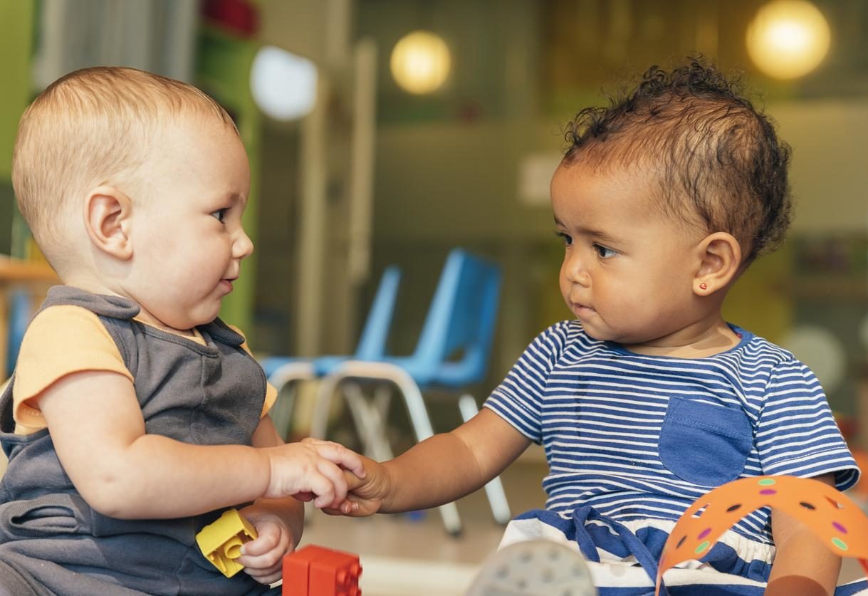 Deux bébés se tenant par la main.