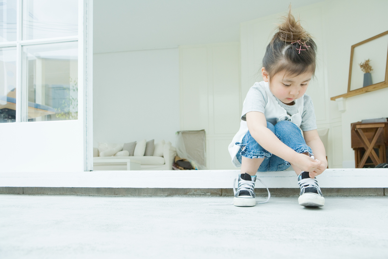 Empowerment : une enfant met ses chaussures toute seule