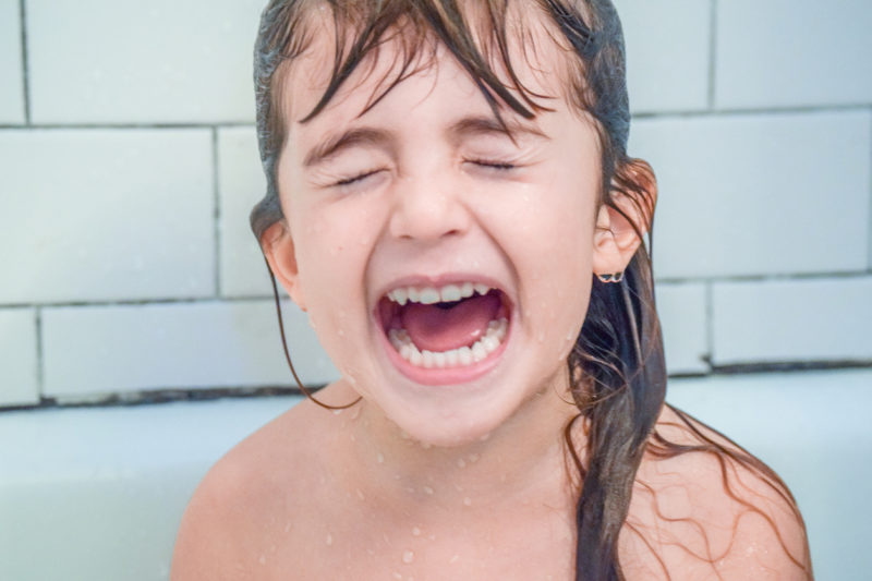 Une enfant qui pleure dans le bain.
