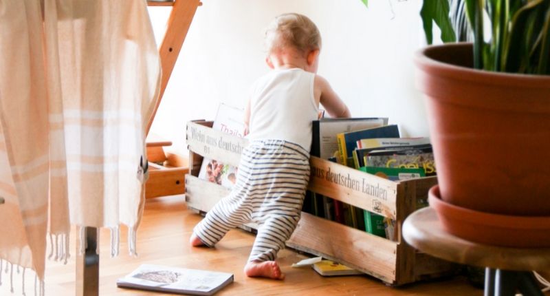 Un jeune enfant qui cherche dans une caisse de livres.