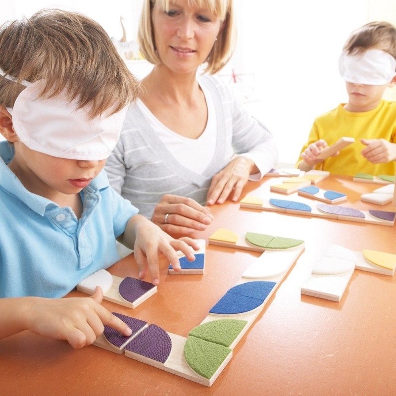 Enfant avec les yeux bandés et des dominos