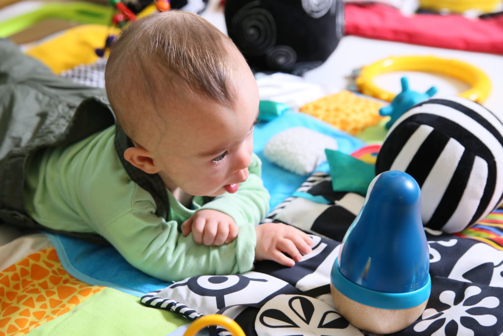 Un bébé observe un jouet en forme de pingouin