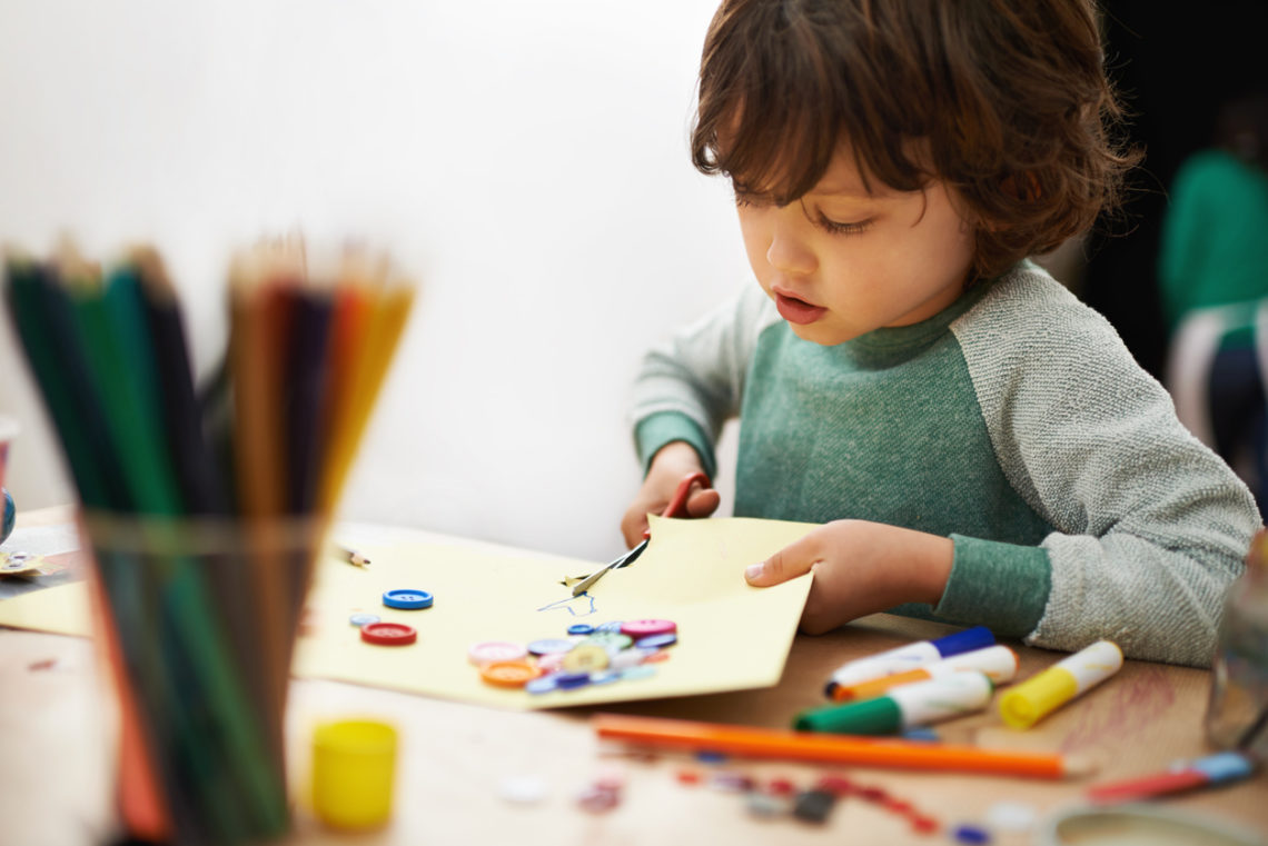 Un enfant qui découpe avec des ciseaux