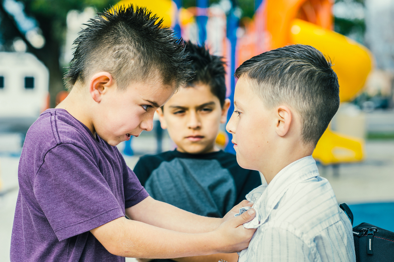 Un enfant tient un autre enfant par le col