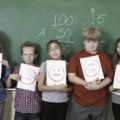 Des enfants alignés devant un tableau