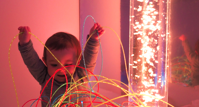 Un enfant joue avec des fibres optiques