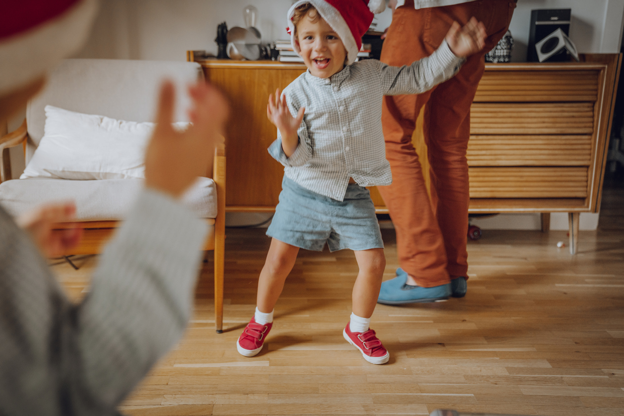 Un enfant danse avec un bonnet de noël 