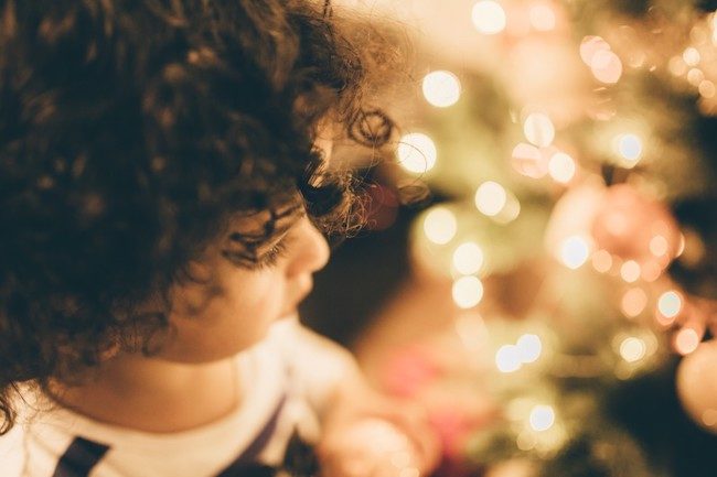 Un enfant regarde un sapin de Noël