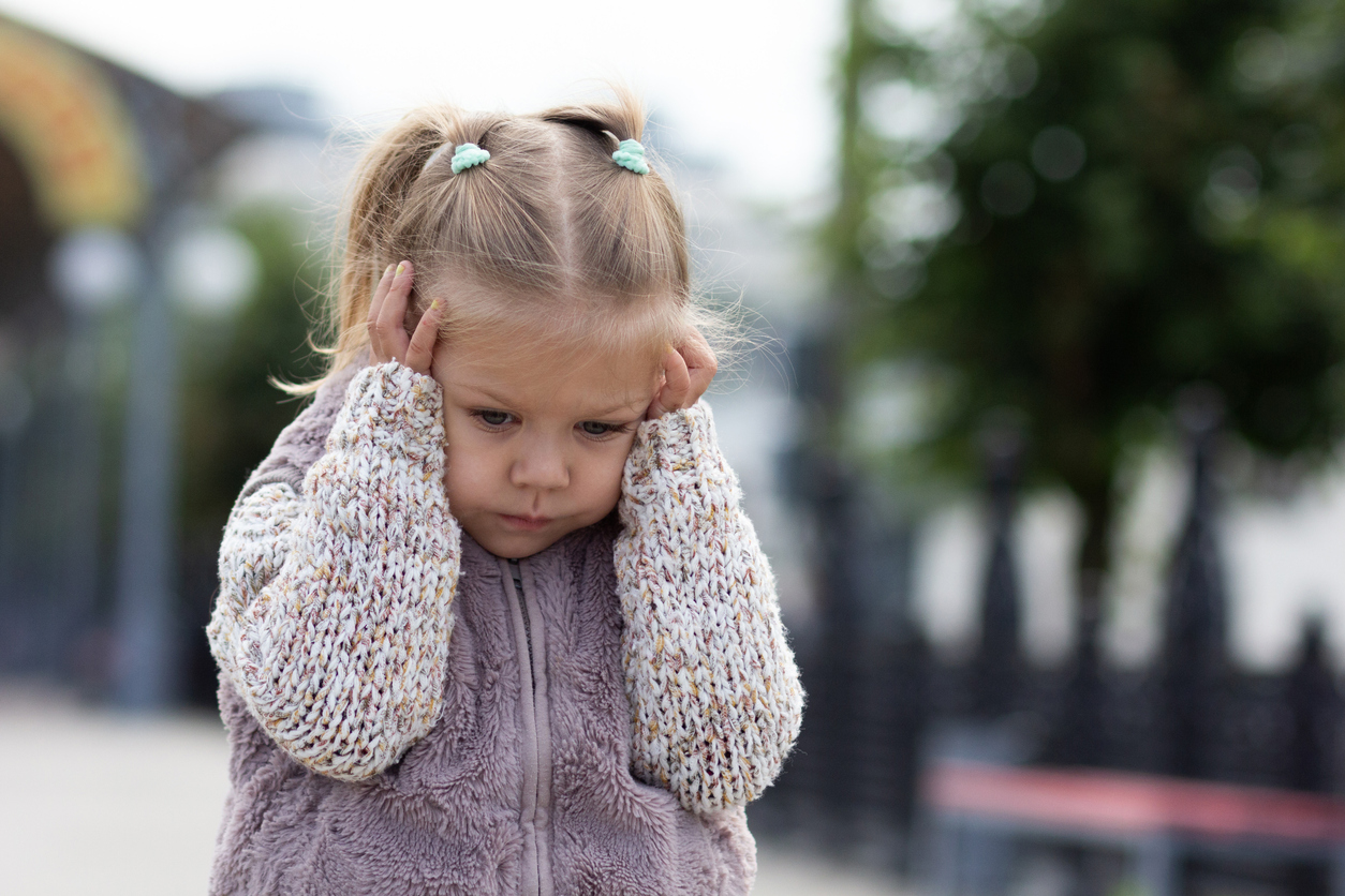 Enfant hypersensible qui se tient la tête avec les mains