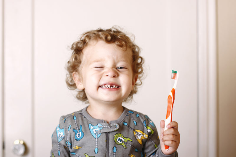 Un garçon se brosse les dents pour préserver sa santé bucco-dentaire