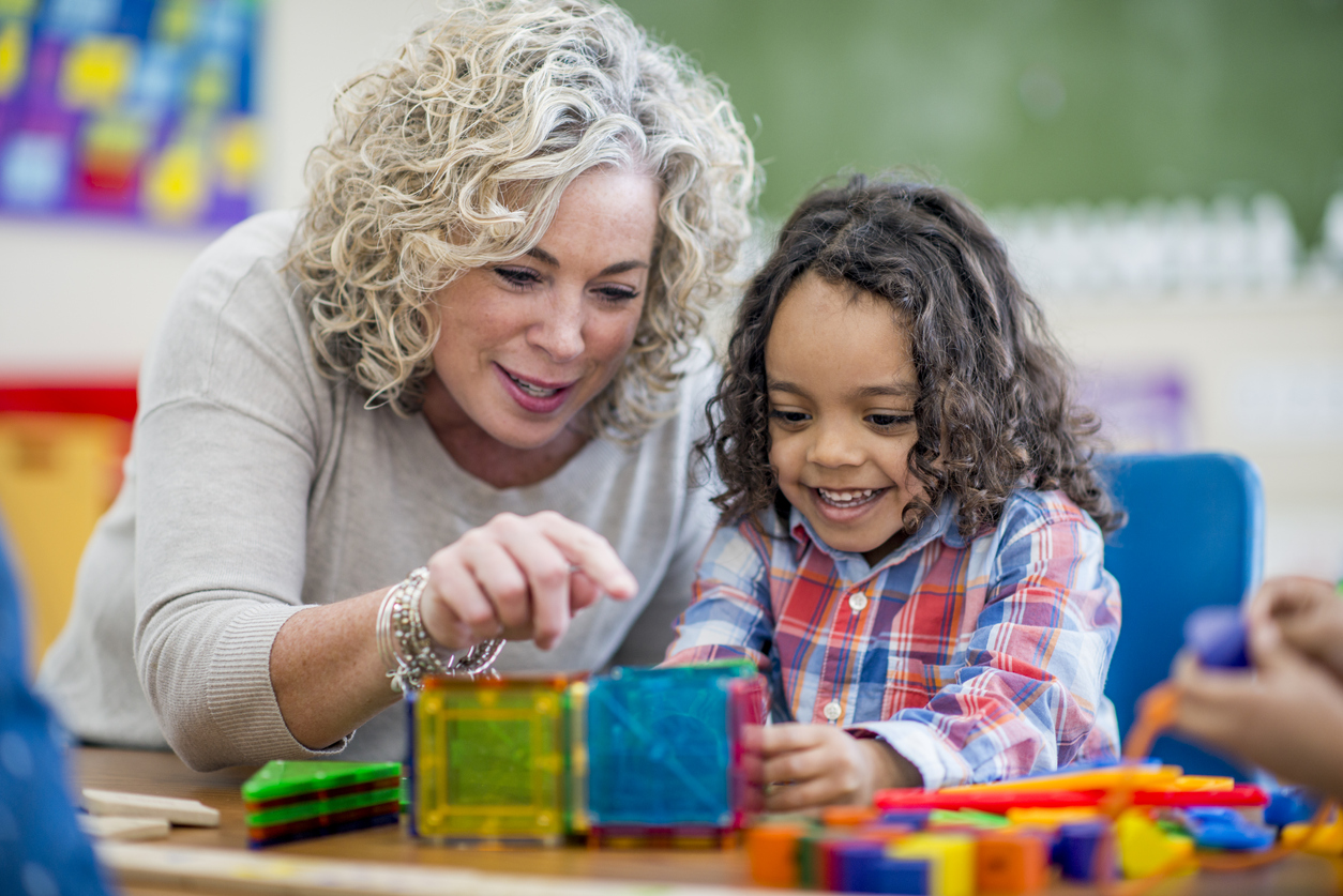 Une enseignante avec un enfant pendant des apprentissages.