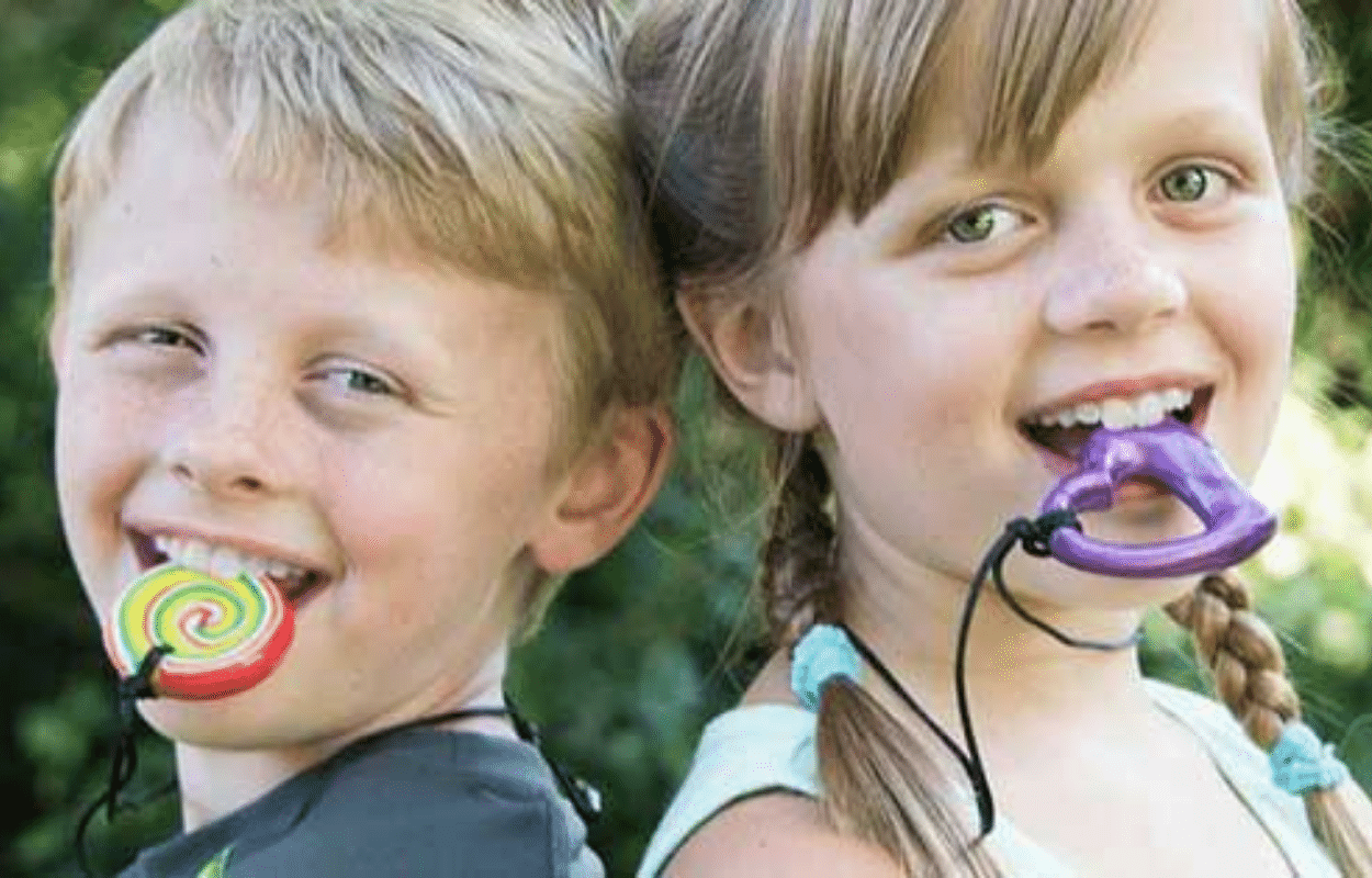 Dos niños de espaldas con collares Chewigem