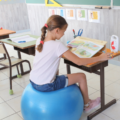 Une élève est assise sur une Sitting Ball