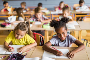 Enfants assis en salle de classe à école