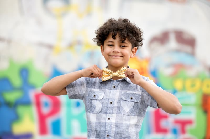 Un enfant fier de lui avec un nœud papillon doré