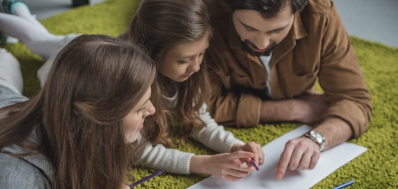 Des parents pointent du doigt une feuille à leur enfant