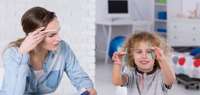 Un enfant casse un crayon en deux