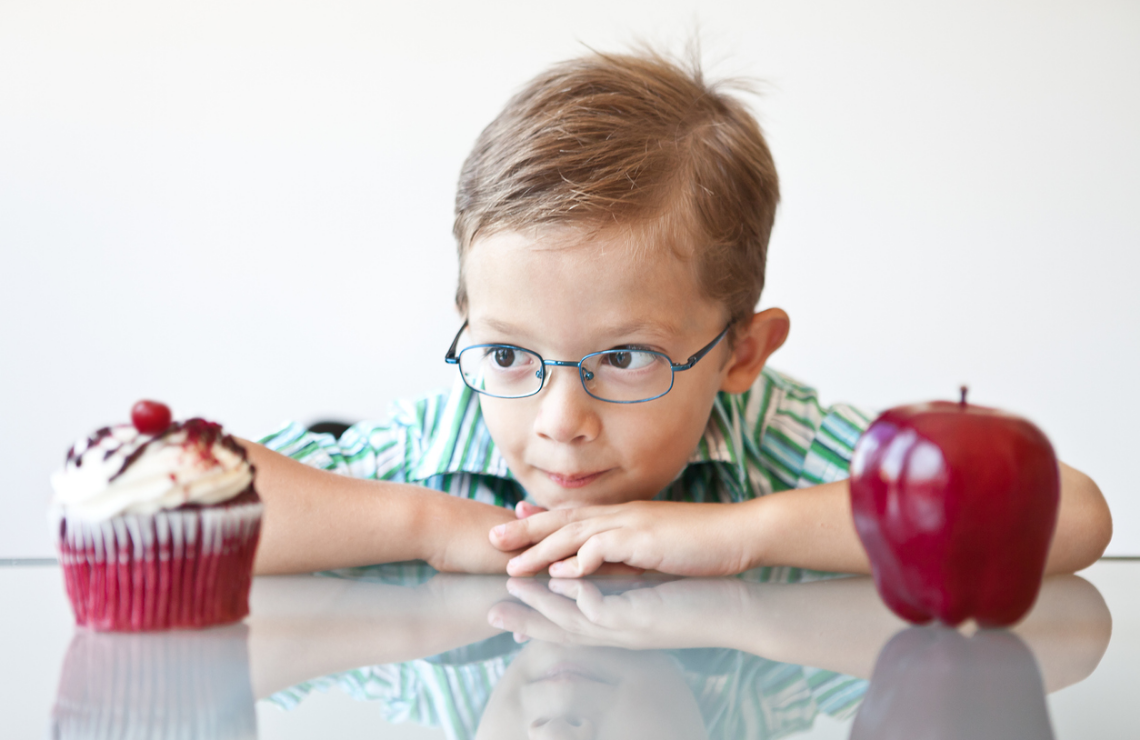 Un enfant choisit entre un gâteau et une pomme autodétermination