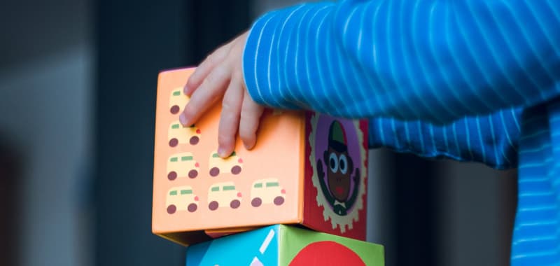 Empowerment : un enfant pose un cube sur une pile de cubes