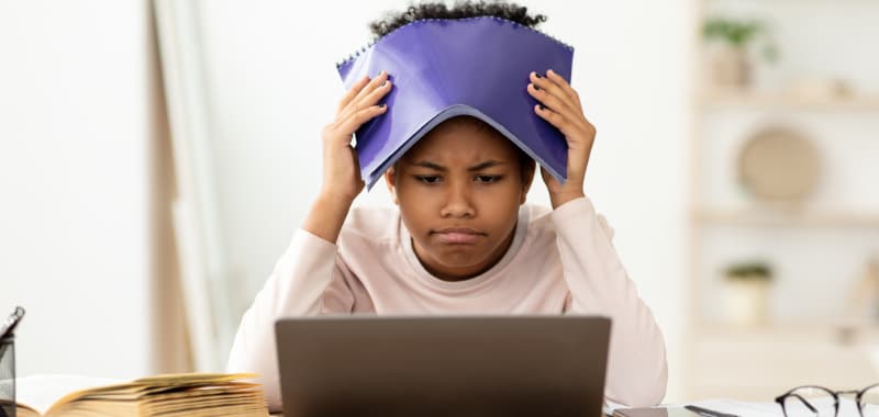 Une jeune fille frustrée devant ses devoirs