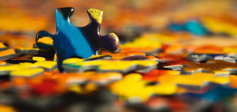 Pièce de puzzle isolée dans un tas de pièces de puzzle