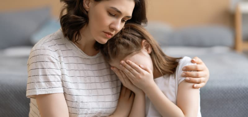 Une mère console et aide sa fille faisant du refus scolaire anxieux