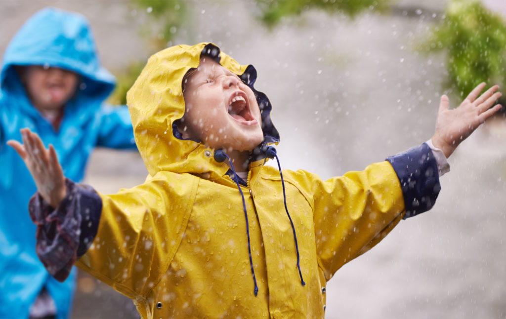 Un enfant est heureux sous la pluie