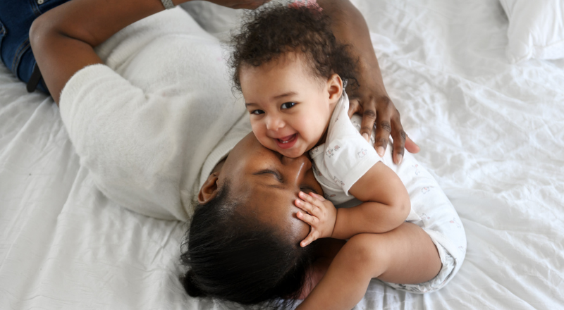 Bébé qui rigole sur le lit