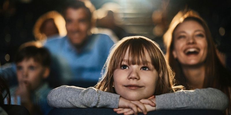 Une fille regarde un film au cinéma