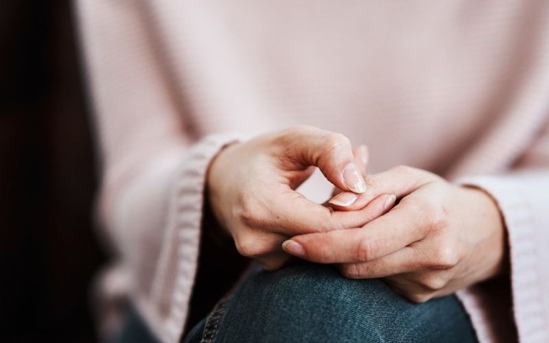 Une femme triture la peau autour de ses ongles