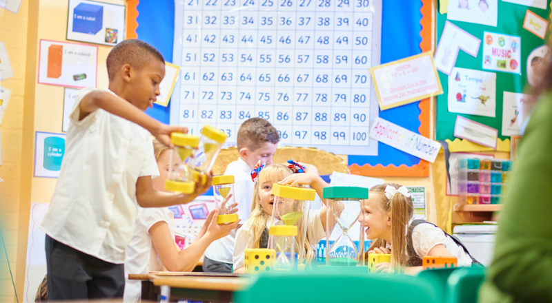 Les enfants font une activité dés avec les sabliers