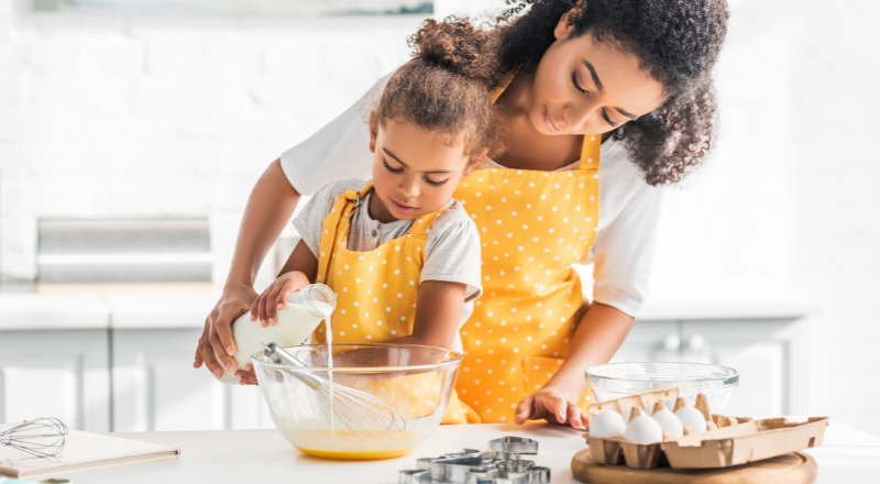 Une petite fille fait de la pâtisserie avec sa maman